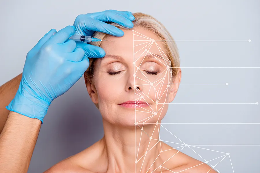 A mature blonde woman gets a facial injection. Get injectable aesthetic treatments from Yashoda Singh, MD in Hamilton-Toronto-Niagara.