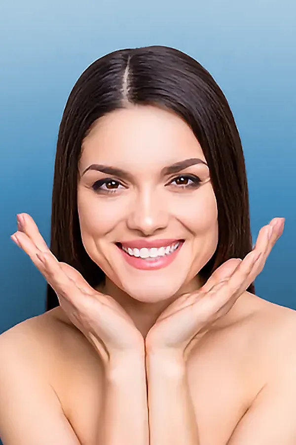 A woman frames her face with her hands. Get blue light therapy for skin from Yashoda Singh, MD in Hamilton-Toronto-Niagara.