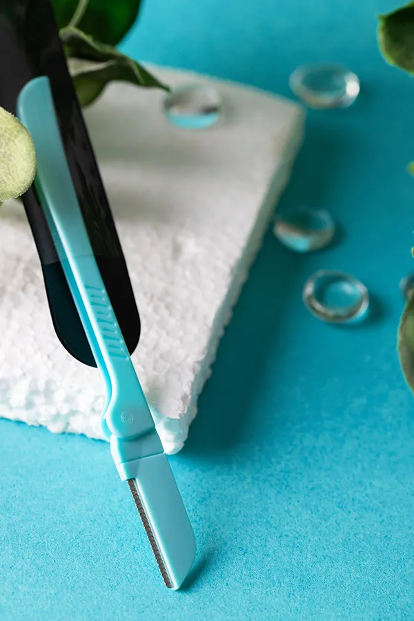 A middle-aged woman smiling in a brightly lit room. Get FemiWave treatment from Yashoda Singh, MD in Hamilton-Toronto-Niagara.