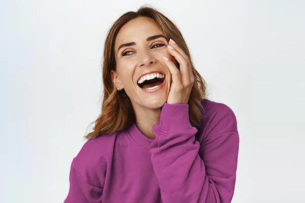 A beautiful woman in a purple shirt. Schedule exosome facial injections from Yashoda Singh, MD in Hamilton-Toronto-Niagara.