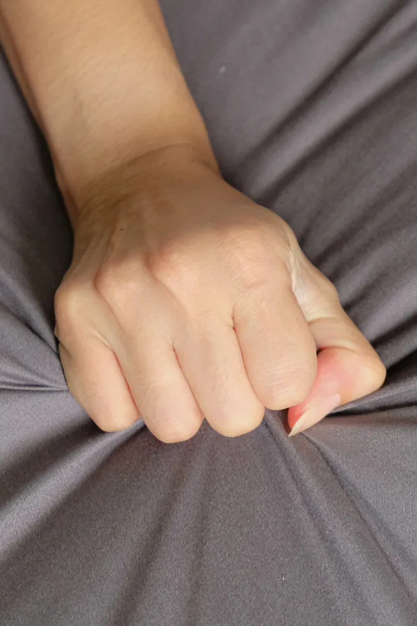 Close-up of a woman's hand grabbing a sheet, indicating sexual pleasure. Get female sexual dysfunction treatment from Yashoda Singh, MD in Hamilton-Toronto-Niagara.