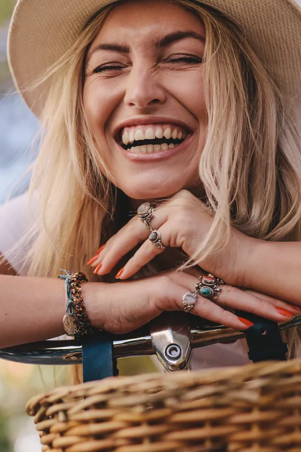 A woman leans on her handlebars laughing. Get green toning treatment for patchy skin from Yashoda Singh, MD in Hamilton-Toronto-Niagara.