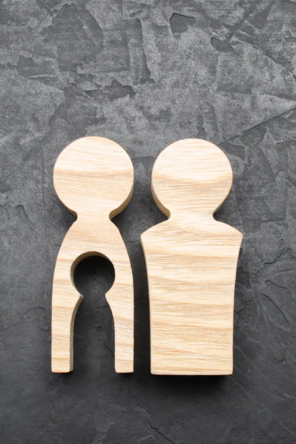 Woodcut figures of a man and woman with a child-shaped area cut out from the woman figure. Get treatment for infertility from Yashoda Singh, MD in Hamilton-Toronto-Niagara.