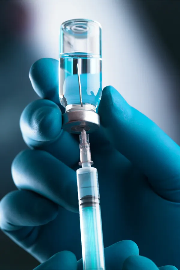 A clinician drawing fluid from a vial. Get Kybella Facial Injections from Yashoda Singh, MD in Hamilton-Toronto-Niagara.