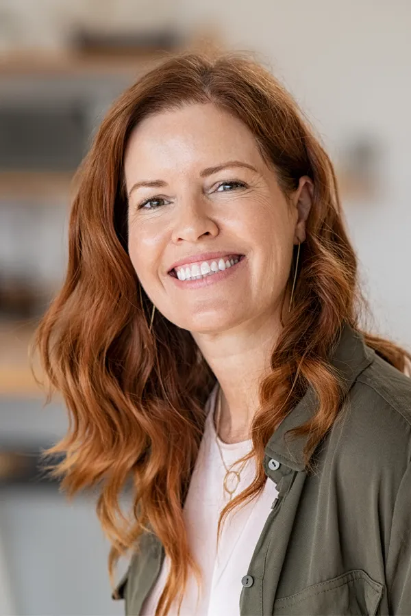 A woman with long lustrous red hair. Get laser hair restoration treatment from Yashoda Singh, MD in Hamilton-Toronto-Niagara.