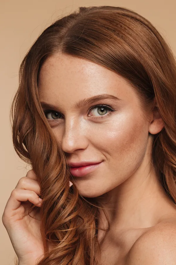 A beautiful woman with long auburn hair. Get laser skin peel treatment from Yashoda Singh, MD in Hamilton-Toronto-Niagara.