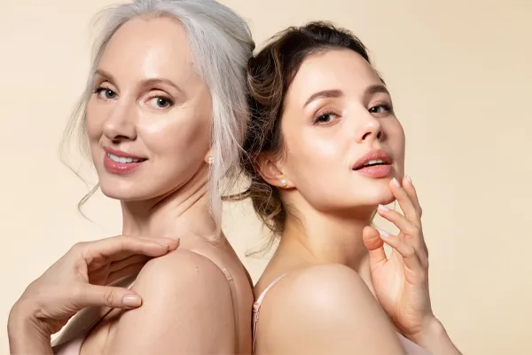 A mature woman with silver hair and a young woman both show their beautiful radiant skin. Get skincare solutions from Yashoda Singh, MD in Hamilton-Toronto-Niagara.