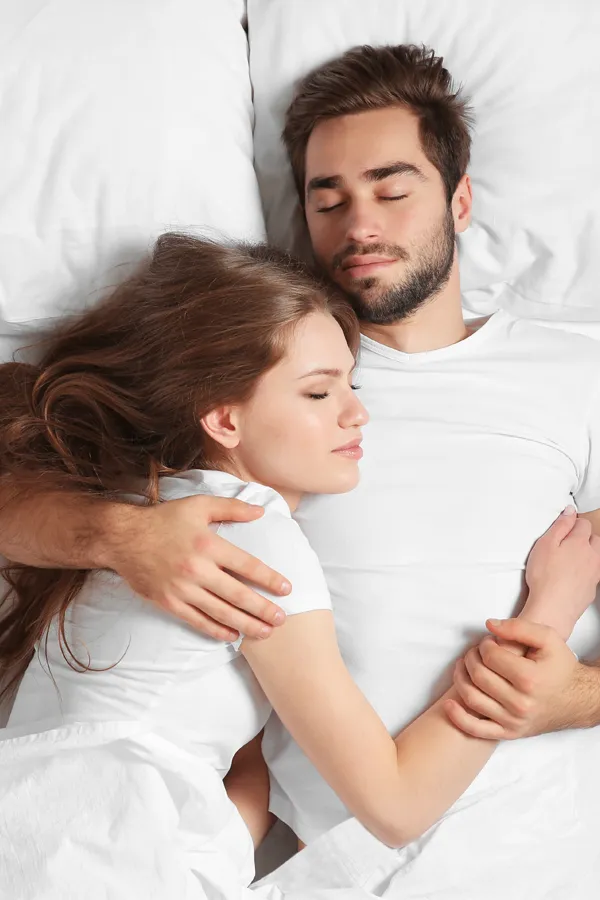 A couple sleep peacefully in each other's arms. Get sleep apnea and snoring treatment from Yashoda Singh, MD in Hamilton-Toronto-Niagara.